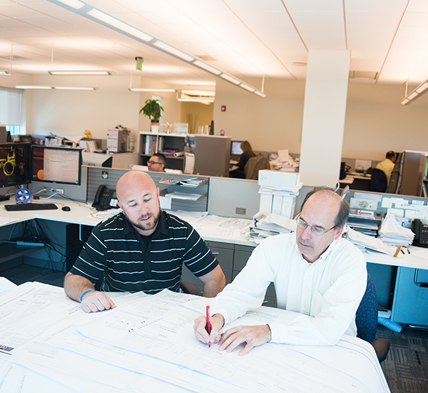 Driven by our mission 2 engineers looking over blueprints