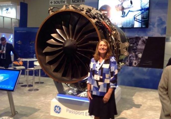 Woman in multi colored shirt/black skirt and jet engine