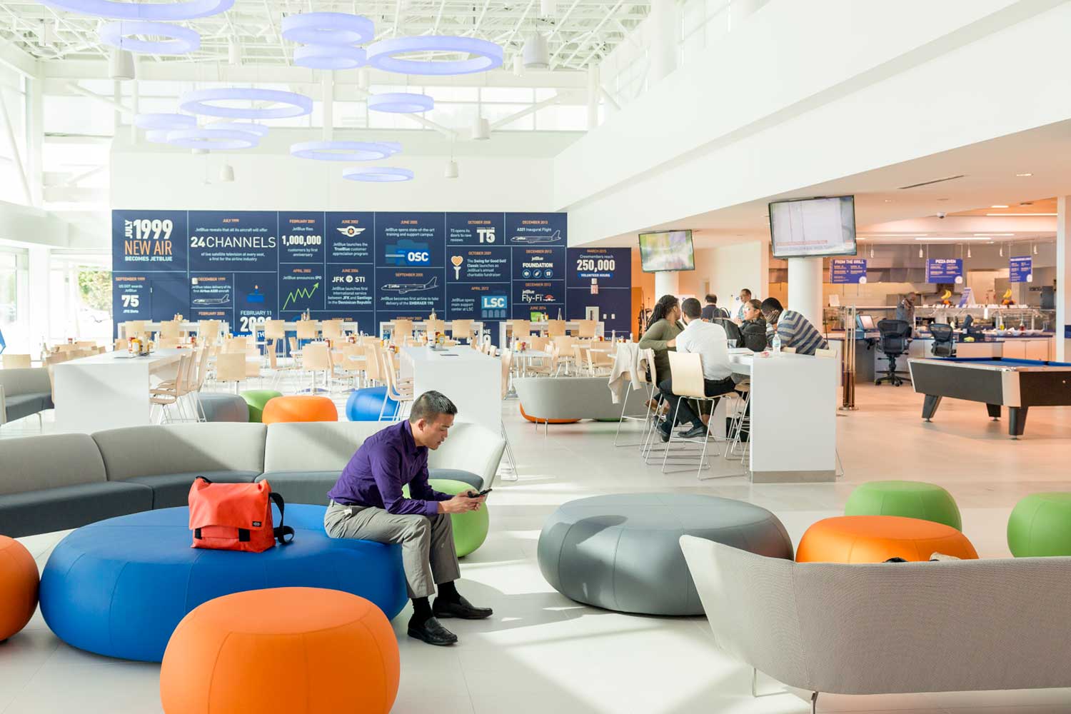Lobby with round blue/gray/green/orange seating and people gathered