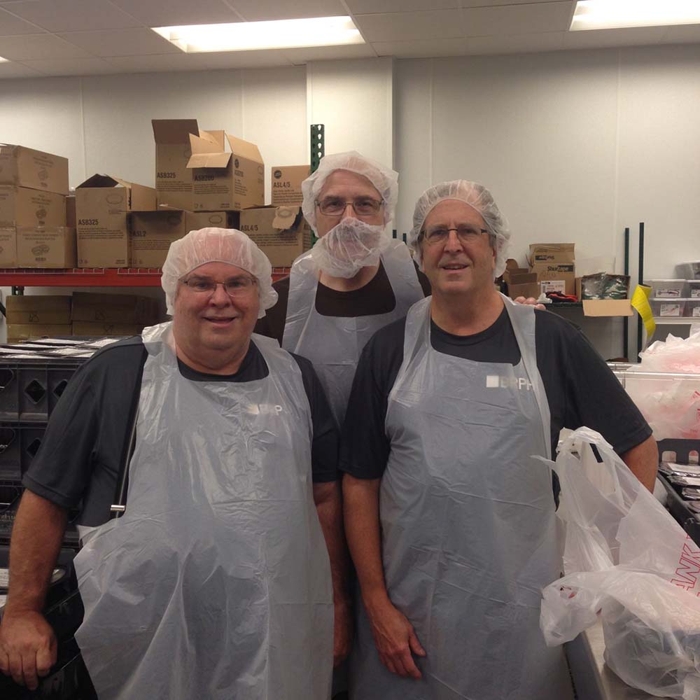 3 men serving food for homeless in ATL