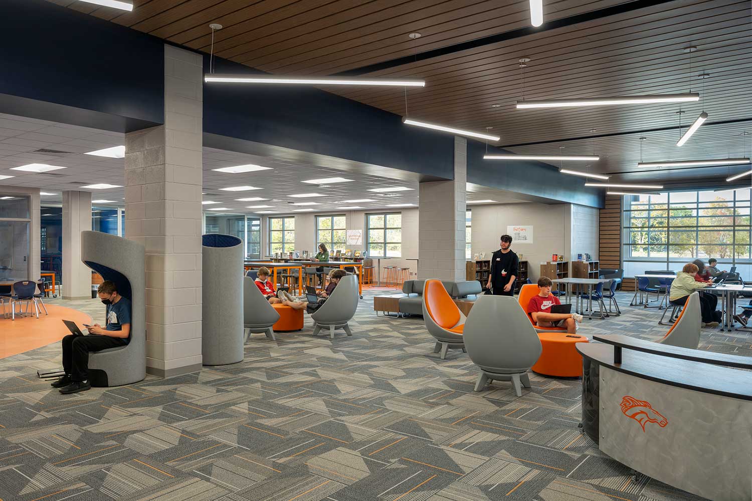 School library with gray floors and orange/gray chairs