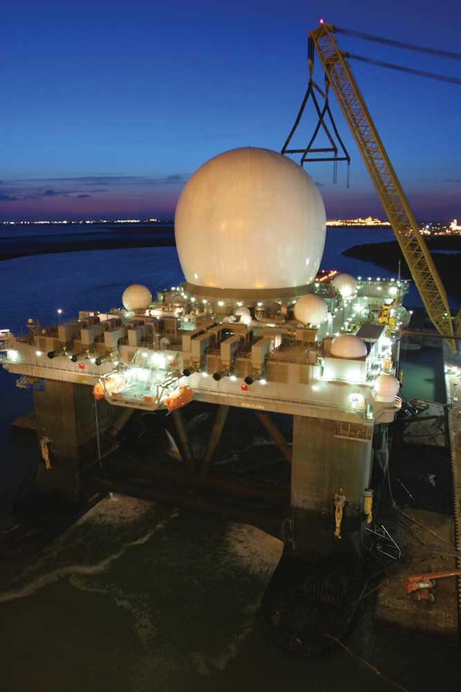 Large white antenna globe on dock station at night