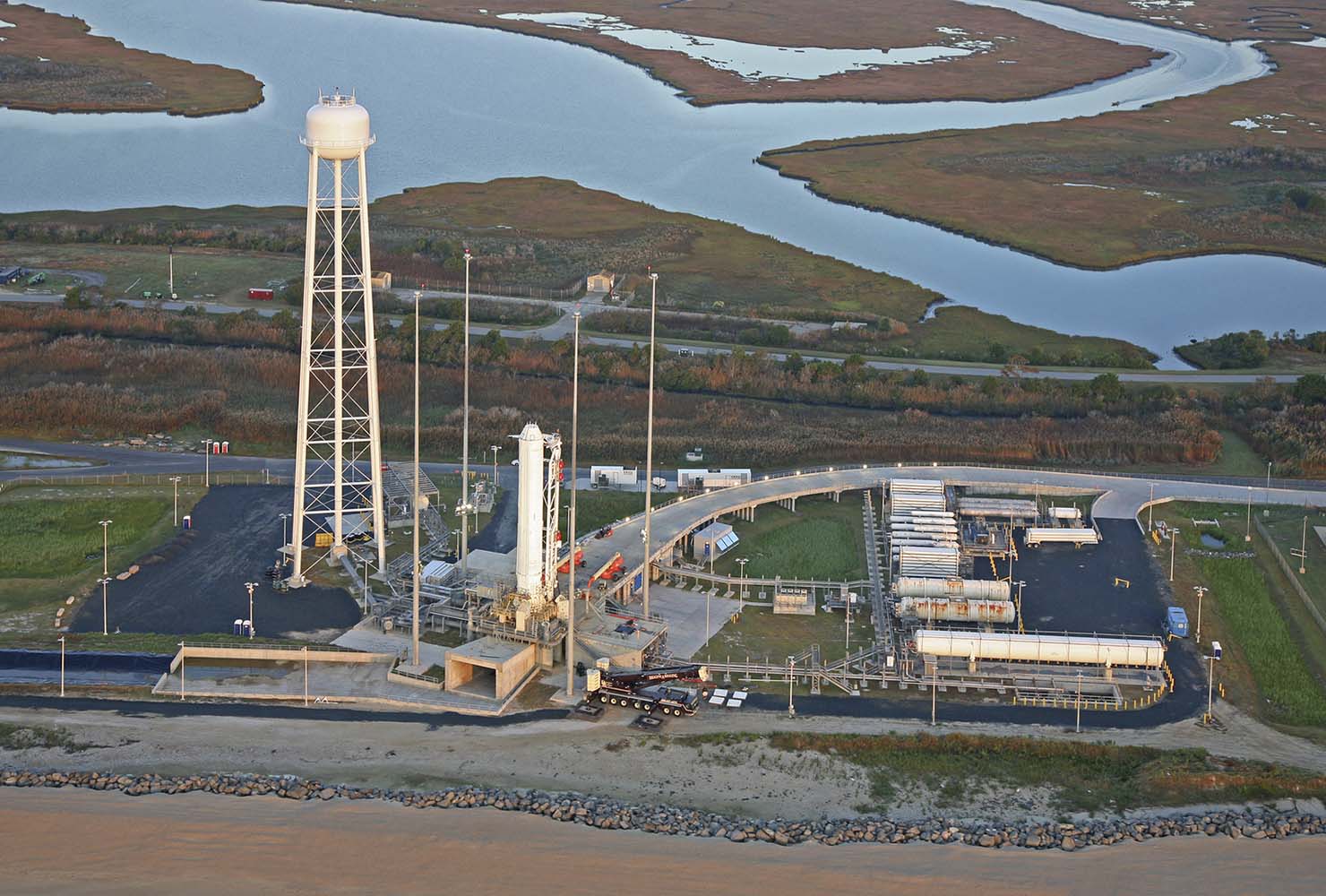 Aerial shot of Wallops Island Pad 0A in Wallops, Virginia. showing rocket on launch page and a large water tower