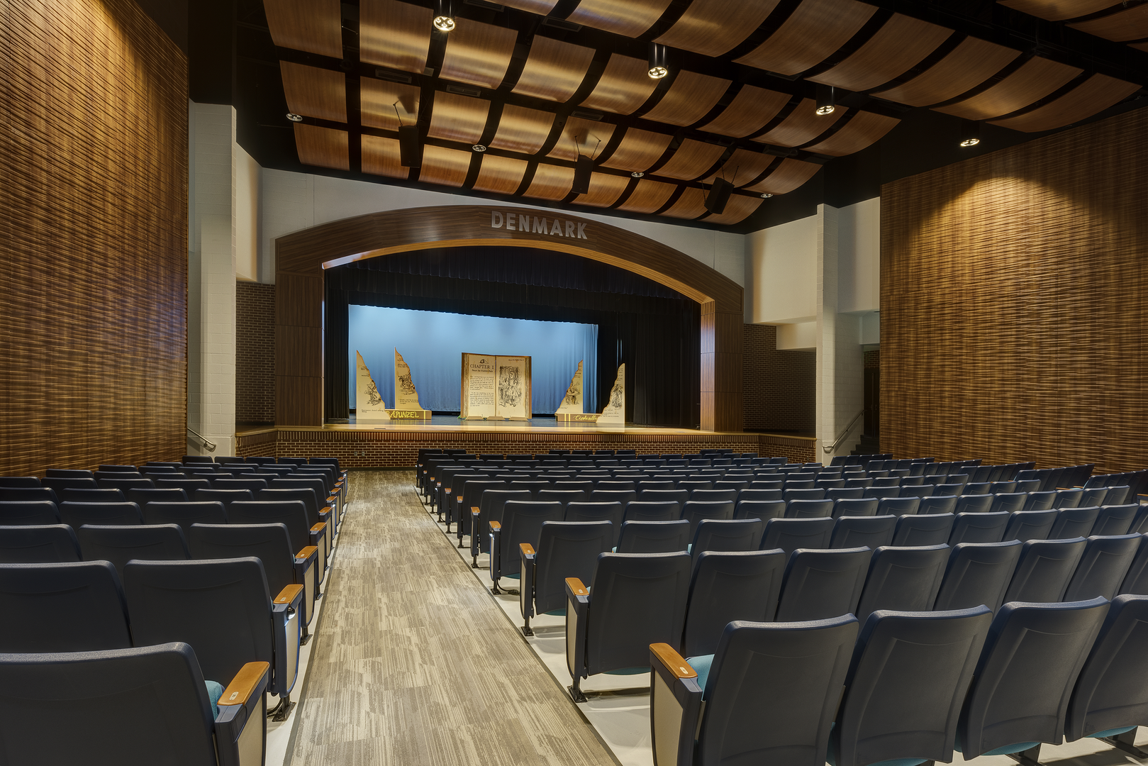 Auditorium with black chairs and brown walls/ceiling