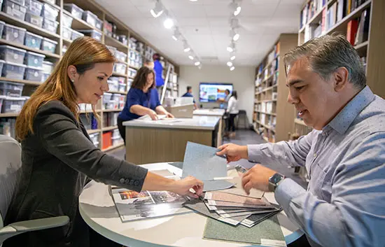 two team members sitting around a table looking at color swatches
