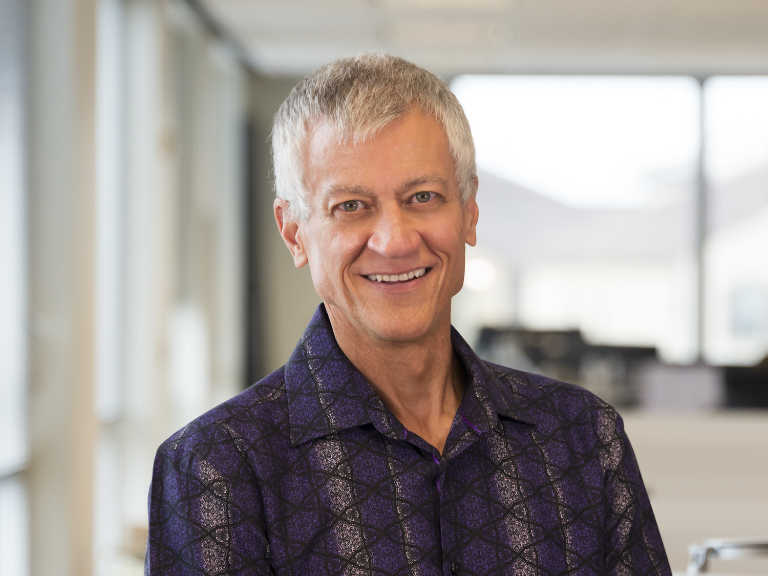 Man smiling in patterned shirt