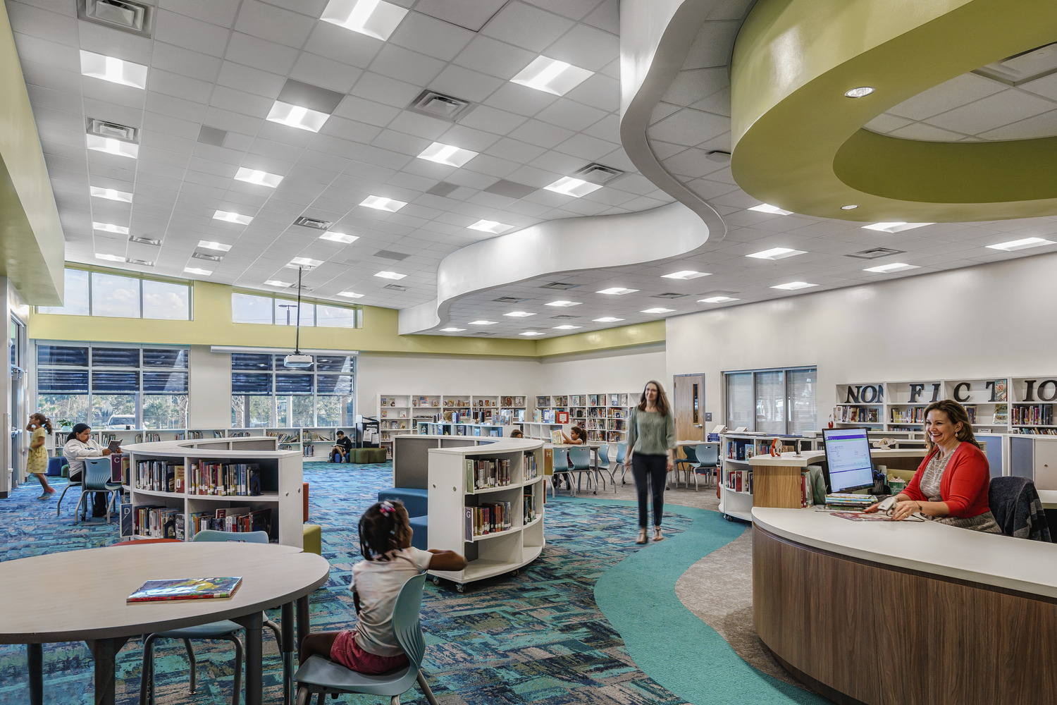 Large school library with curved fixtures and people walking around