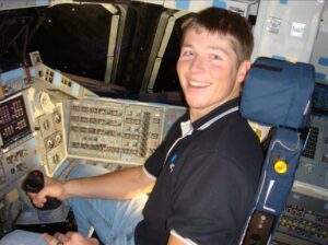 Man sitting in space shuttle cockpit