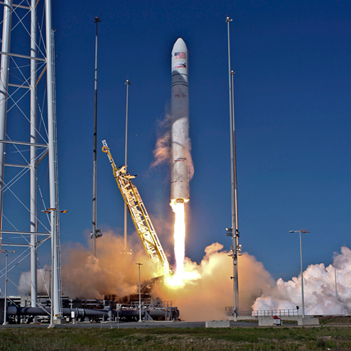 antares three people sitting at a conference table with one of them pointing forward