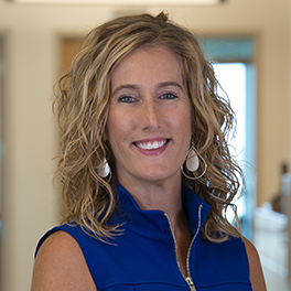 woman with blonde curly hair and blue shirt
